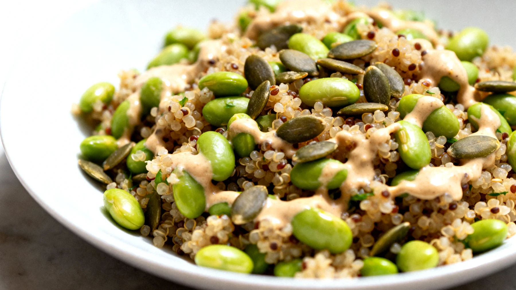 Insalata di quinoa con edamame, semi di zucca e tahina"
